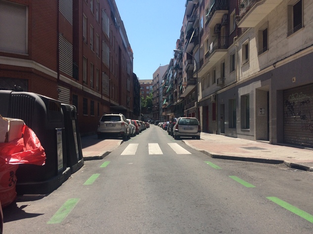 Contenedores reduciendo visibilidad en paso de peatones.