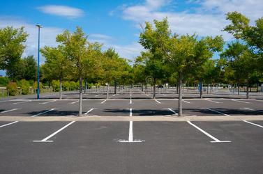 estacionamiento-vacío-con-los-árboles-en-día-de-verano-soleado-122400241.jpg