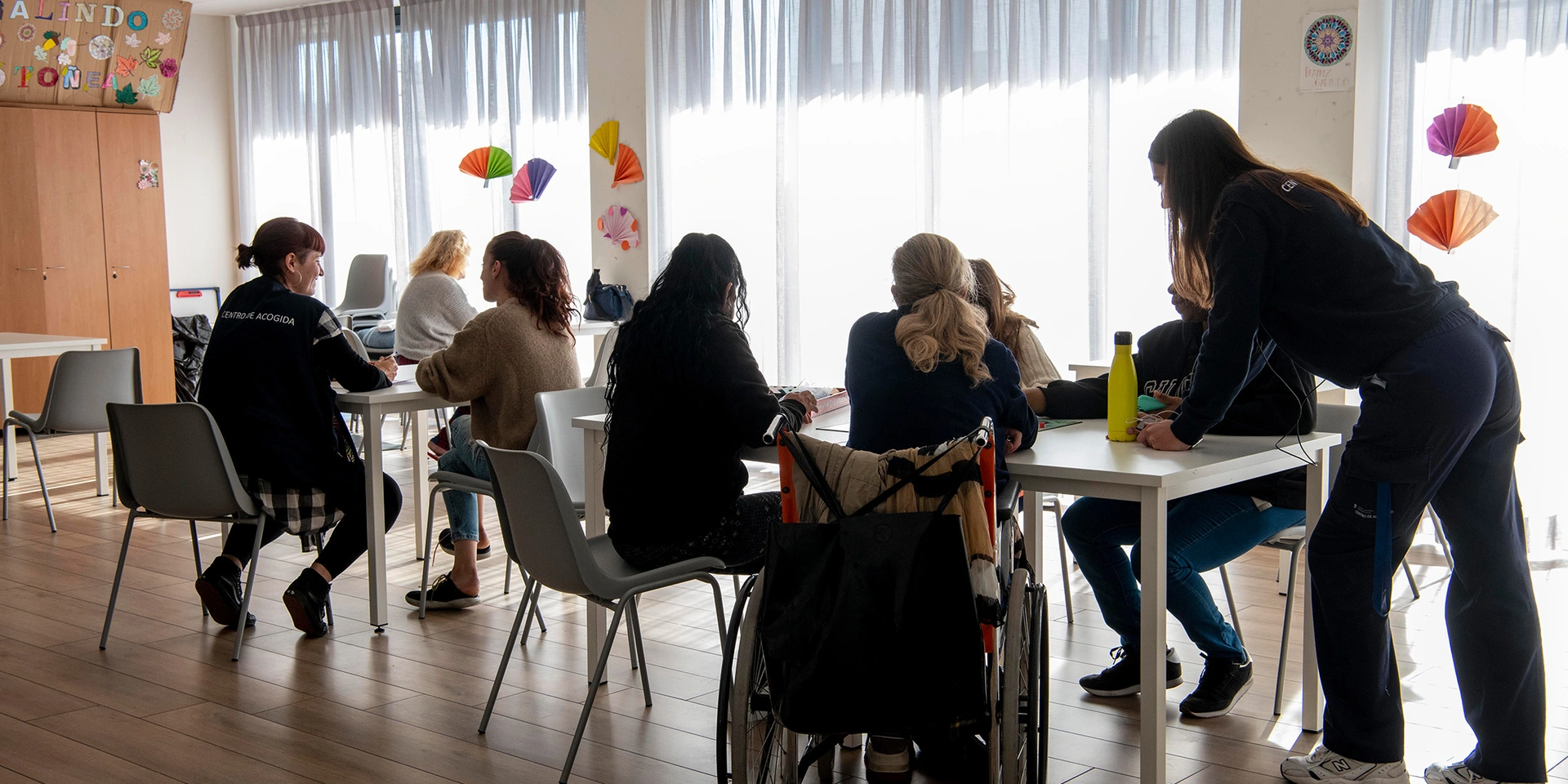 Dos técnicas de servicios sociales atienden a usuarias en un comedor.